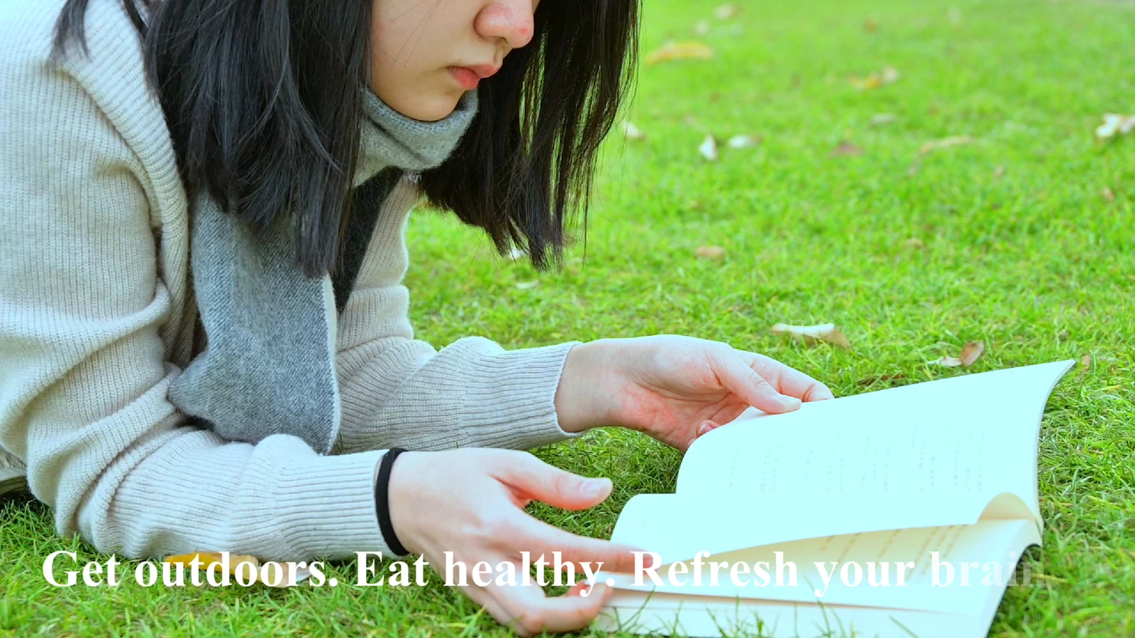Frame from the Brain Health PSA showing outdoor reading on grass, with the film’s original English text.